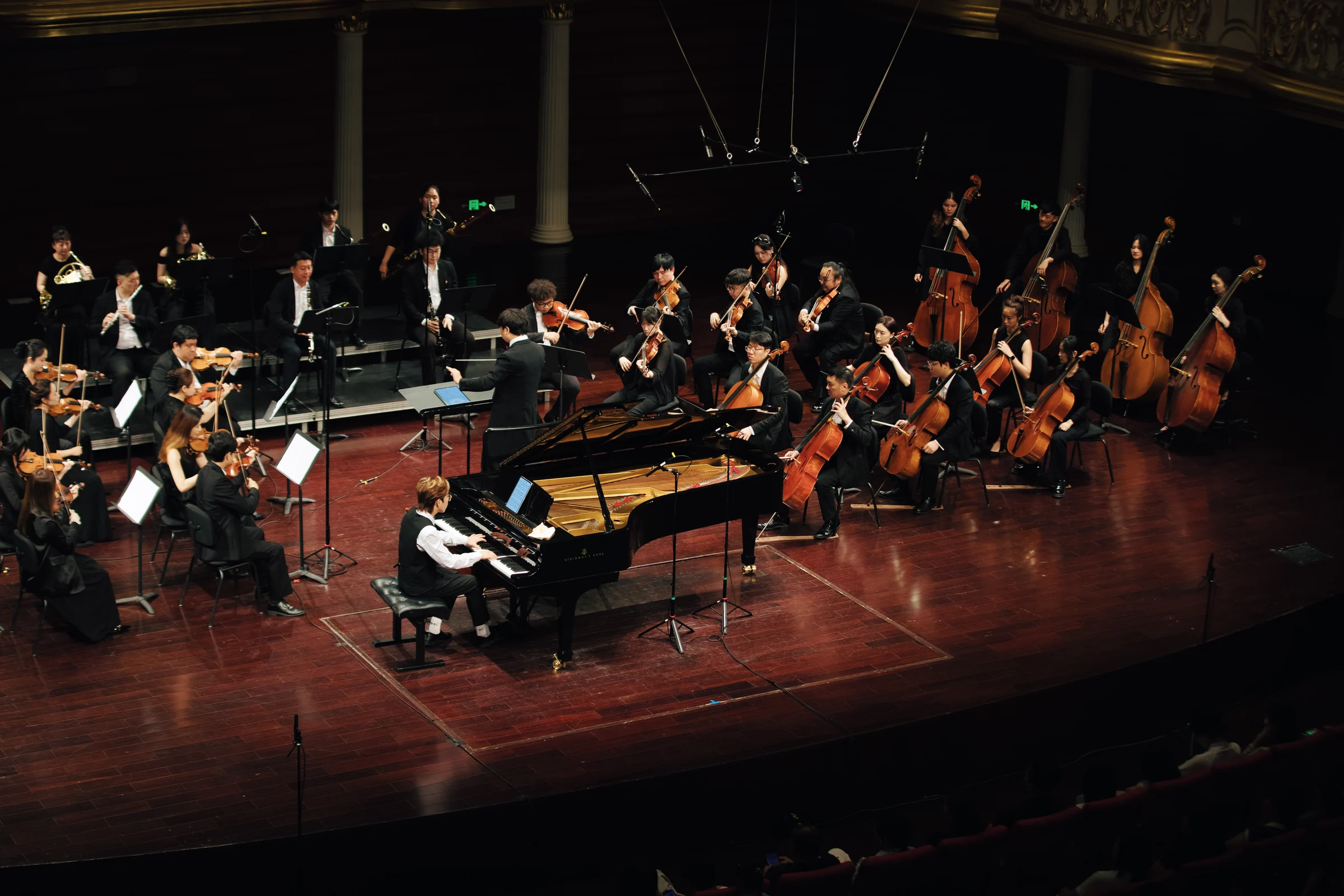 A side view of the pianist, conductor and orchestra